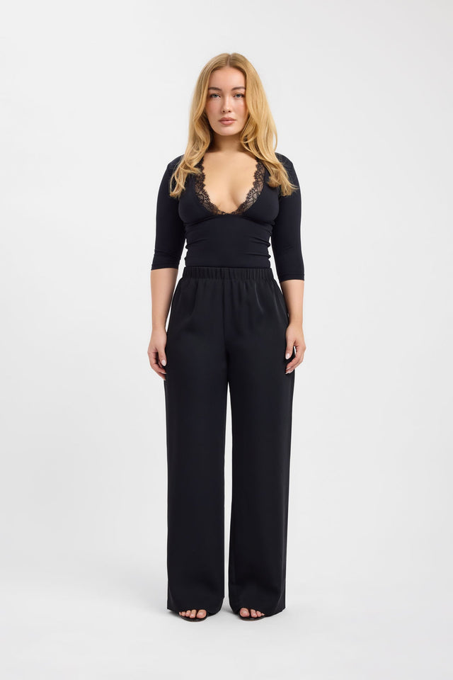 Presenting the Riley Lace Top womens-blouse in black with fitted plunge neckline and three-fourth sleeves on-body