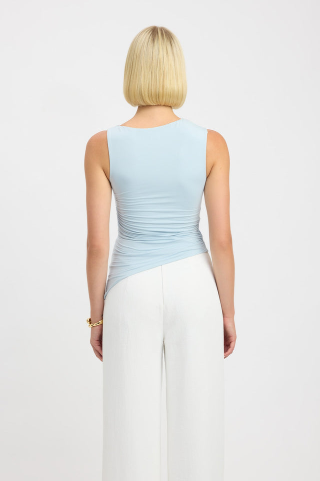 Close up back profile of light blue sleeveless asymmetric hemline tank top.